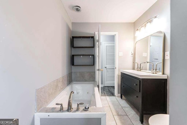 full bath with tile patterned floors, a tub with jets, and vanity