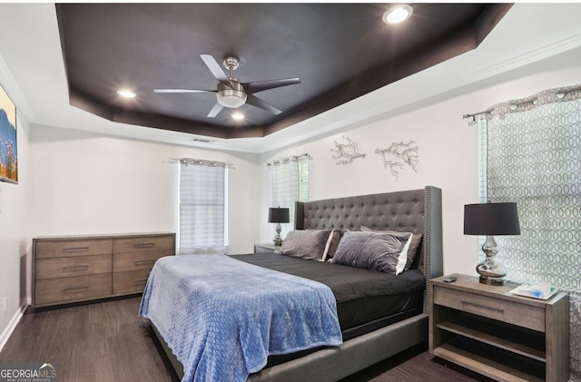 bedroom with dark wood finished floors, baseboards, recessed lighting, and a tray ceiling