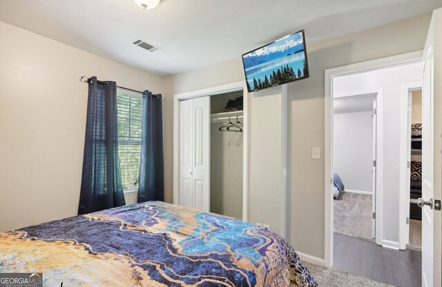 bedroom featuring a closet, visible vents, wood finished floors, and baseboards