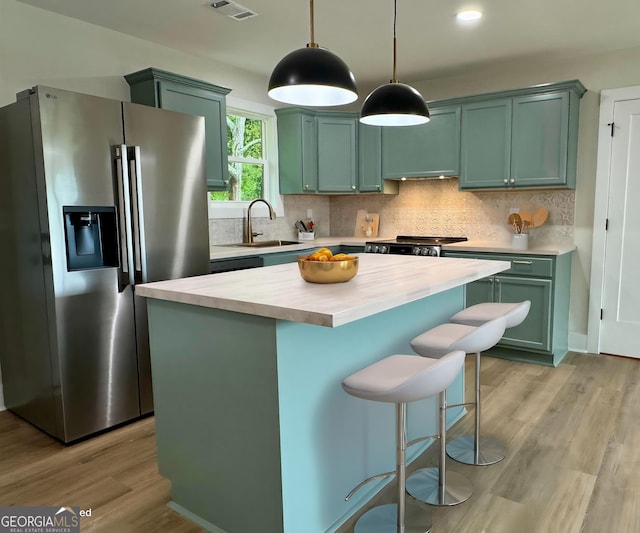 101 Newsome St, Union Point, GA 30669 - kitchen featuring stainless steel refrigerator with ice dispenser, green cabinets, a sink, hanging light fixtures, and a center island