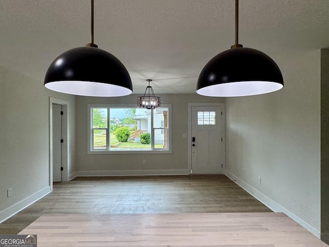 101 Newsome St, Union Point, GA 30669 - entrance foyer featuring plenty of natural light, a textured ceiling, baseboards, wood finished floors, and a chandelier