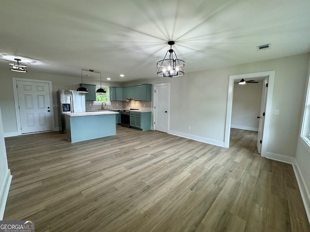 101 Newsome St, Union Point, GA 30669 - kitchen with stainless steel fridge with ice dispenser, backsplash, light wood finished floors, baseboards, and a center island