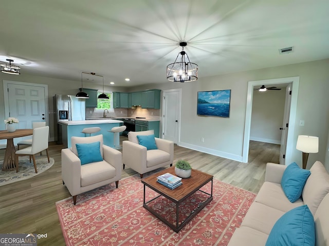 101 Newsome St, Union Point, GA 30669 - living area featuring light wood-style floors, a chandelier, baseboards, and recessed lighting