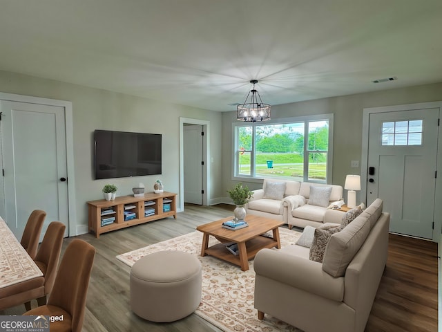 101 Newsome St, Union Point, GA 30669 - living area with a chandelier, wood finished floors, healthy amount of natural light, and baseboards