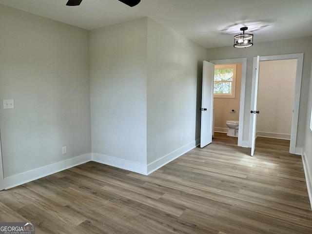 101 Newsome St, Union Point, GA 30669 - unfurnished bedroom featuring baseboards, wood finished floors, and ensuite bathroom