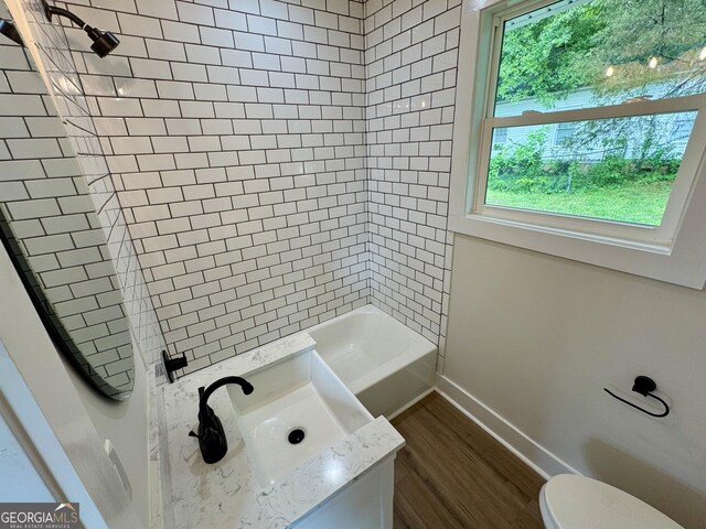101 Newsome St, Union Point, GA 30669 - full bathroom featuring toilet, wood finished floors, baseboards, vanity, and tub / shower combination