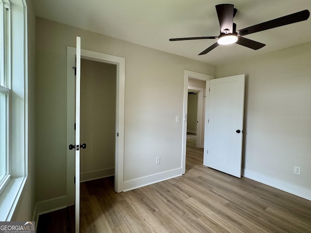101 Newsome St, Union Point, GA 30669 - unfurnished bedroom featuring light wood-style flooring, baseboards, and ceiling fan