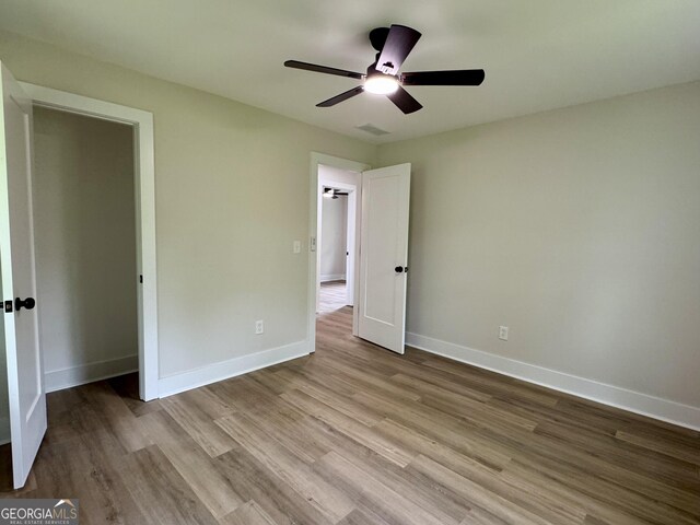 101 Newsome St, Union Point, GA 30669 - unfurnished bedroom featuring wood finished floors, ceiling fan, and baseboards