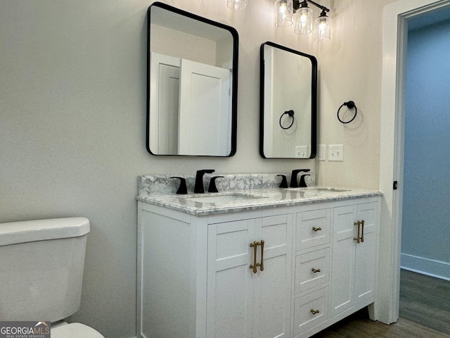 101 Newsome St, Union Point, GA 30669 - bathroom featuring toilet, double vanity, and wood finished floors