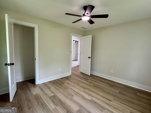 101 Newsome St, Union Point, GA 30669 - unfurnished bedroom with wood finished floors, baseboards, and ceiling fan