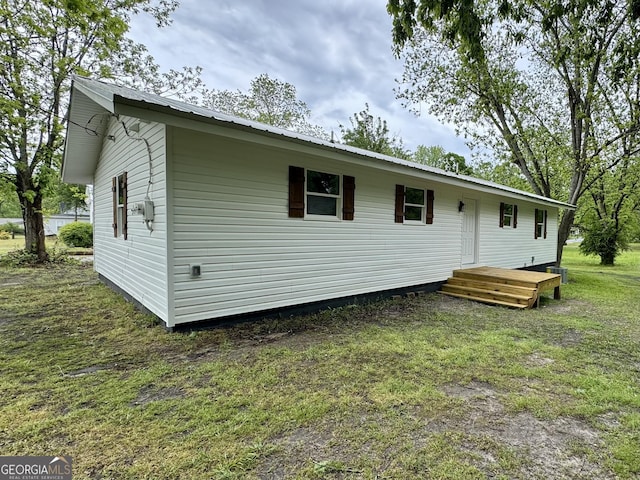101 Newsome St, Union Point, GA 30669 - rear view of property featuring metal roof and a yard