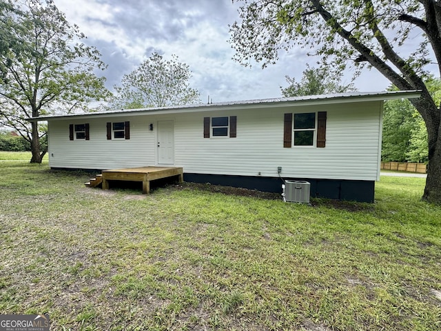 101 Newsome St, Union Point, GA 30669 - back of property featuring a yard, central AC unit, a deck, and metal roof
