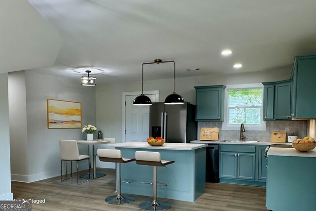 101 Newsome St, Union Point, GA 30669 - kitchen featuring fridge with ice dispenser, a sink, wood finished floors, decorative backsplash, and a center island