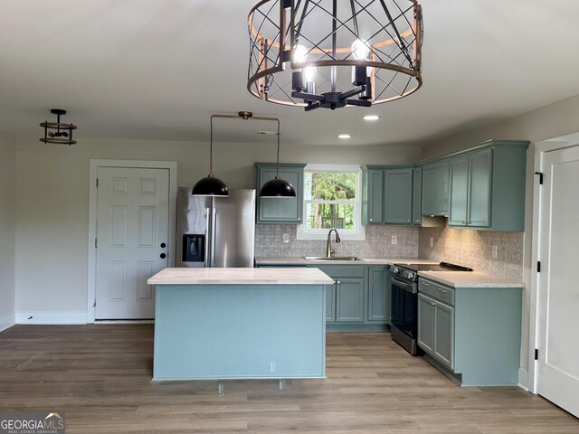 101 Newsome St, Union Point, GA 30669 - kitchen featuring appliances with stainless steel finishes, a sink, a chandelier, light countertops, and a kitchen island