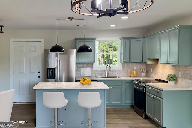 101 Newsome St, Union Point, GA 30669 - kitchen featuring stainless steel appliances, a sink, wood finished floors, light countertops, and green cabinets
