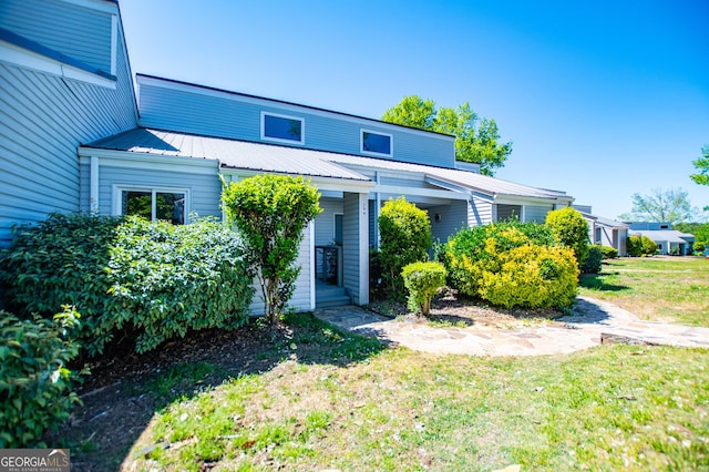 view of front facade featuring a front lawn and metal roof