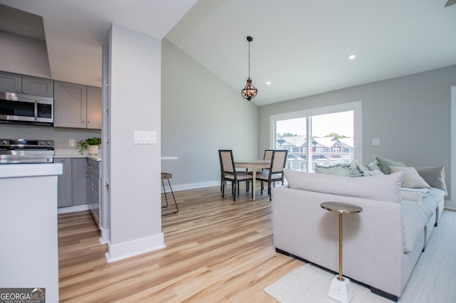 living room with baseboards, recessed lighting, lofted ceiling, and light wood-style flooring