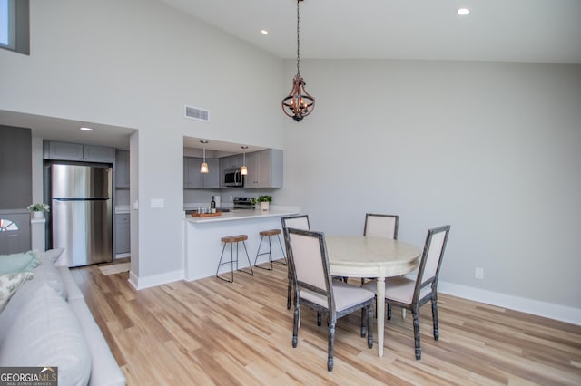 dining area featuring a notable chandelier, light wood-style flooring, and baseboards