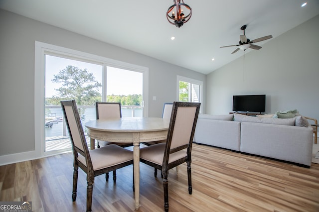 dining area with lofted ceiling, light wood-type flooring, recessed lighting, and ceiling fan with notable chandelier