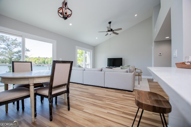 dining room with recessed lighting, high vaulted ceiling, light wood-style flooring, and ceiling fan with notable chandelier