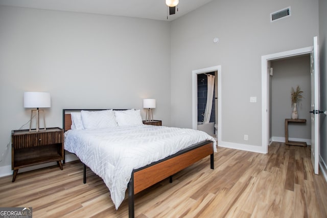 bedroom featuring visible vents, high vaulted ceiling, light wood finished floors, and baseboards