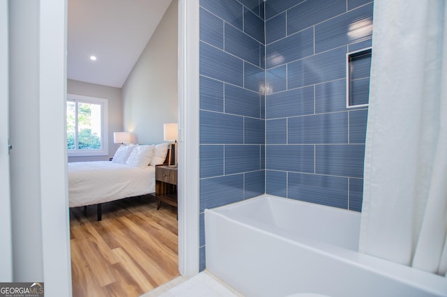 full bathroom featuring wood finished floors, connected bathroom, and tub / shower combination