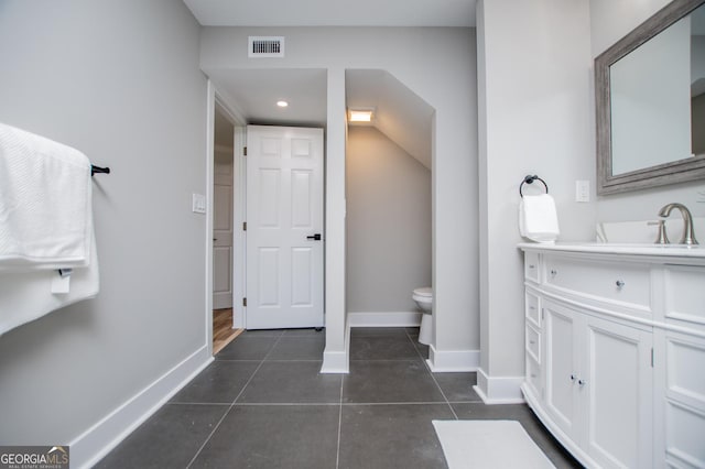 bathroom featuring visible vents, baseboards, toilet, tile patterned floors, and vanity