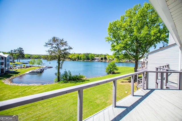 wooden terrace with a lawn and a water view