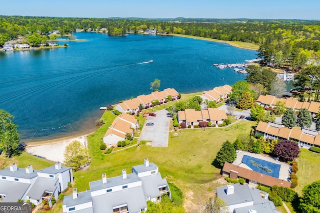bird's eye view featuring a wooded view, a water view, and a residential view