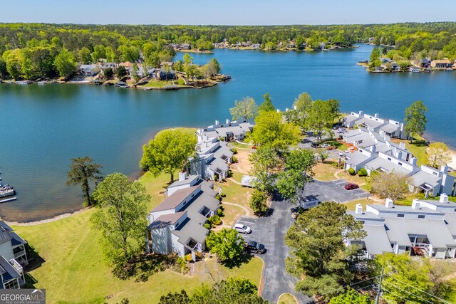 aerial view featuring a wooded view, a residential view, and a water view