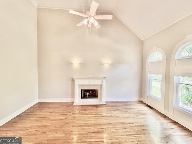 unfurnished living room featuring a fireplace with flush hearth, high vaulted ceiling, crown molding, a ceiling fan, and wood finished floors