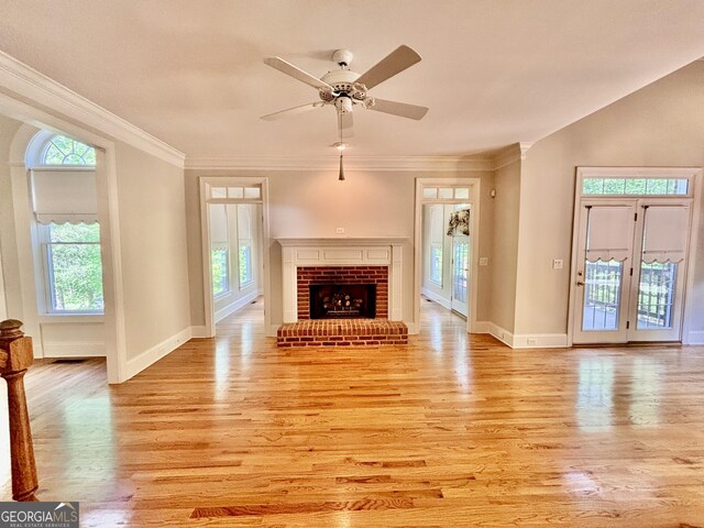 unfurnished living room with baseboards, a wealth of natural light, and light wood finished floors