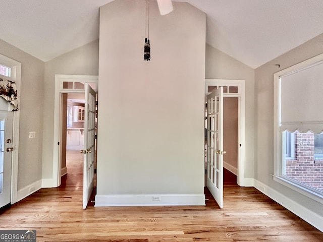 interior space with french doors, vaulted ceiling, and light wood-style floors