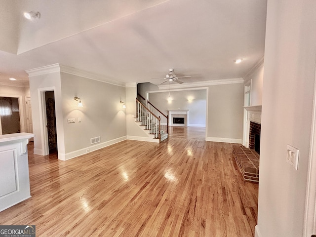 unfurnished living room with visible vents, ornamental molding, and a brick fireplace