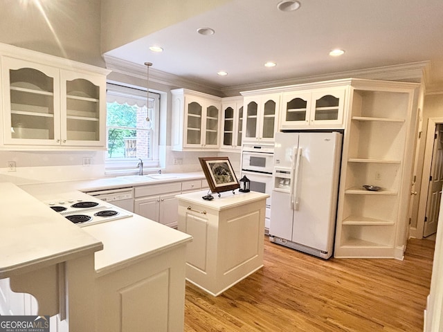 kitchen featuring white cabinets, a sink, light countertops, light wood-type flooring, and white appliances