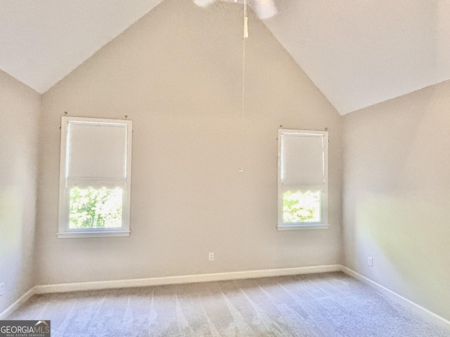 unfurnished room with light carpet, a healthy amount of sunlight, and lofted ceiling
