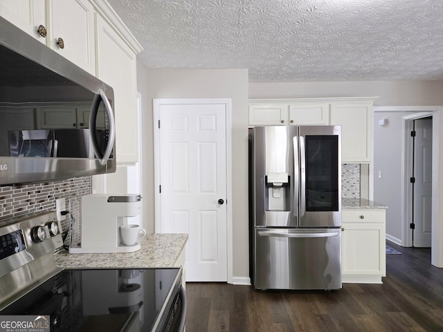 kitchen featuring dark wood finished floors, tasteful backsplash, appliances with stainless steel finishes, and white cabinetry