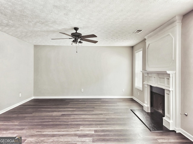 unfurnished living room featuring wood finished floors, a fireplace with raised hearth, baseboards, visible vents, and a ceiling fan