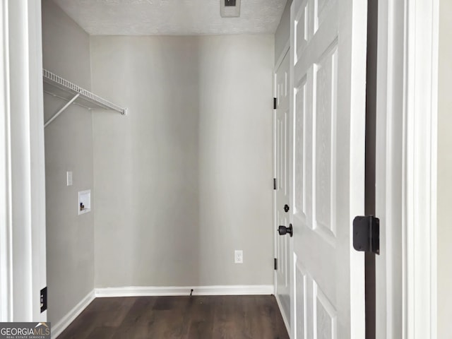clothes washing area with dark wood-style floors, hookup for a washing machine, laundry area, and baseboards