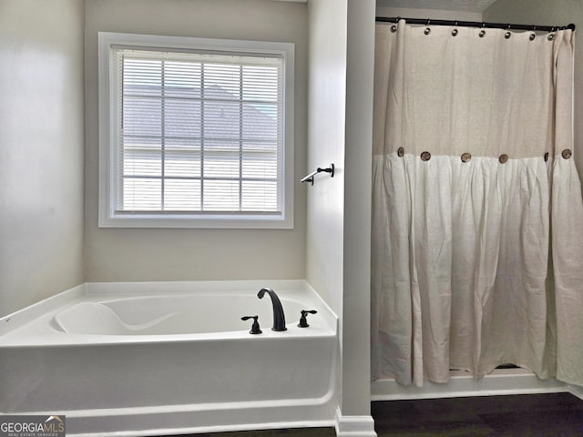 bathroom with curtained shower and a bath