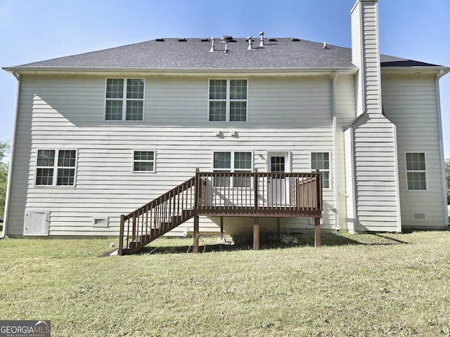 rear view of property featuring a wooden deck, a yard, a chimney, stairs, and roof with shingles