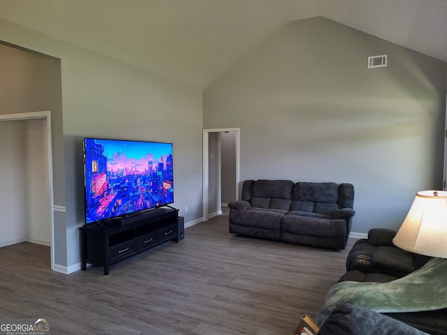 living room with wood finished floors, high vaulted ceiling, visible vents, and baseboards