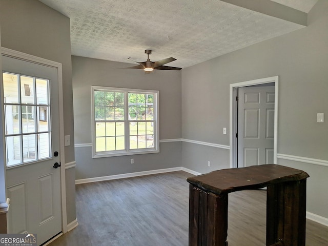 doorway to outside with a textured ceiling, ceiling fan, dark wood-style floors, and baseboards
