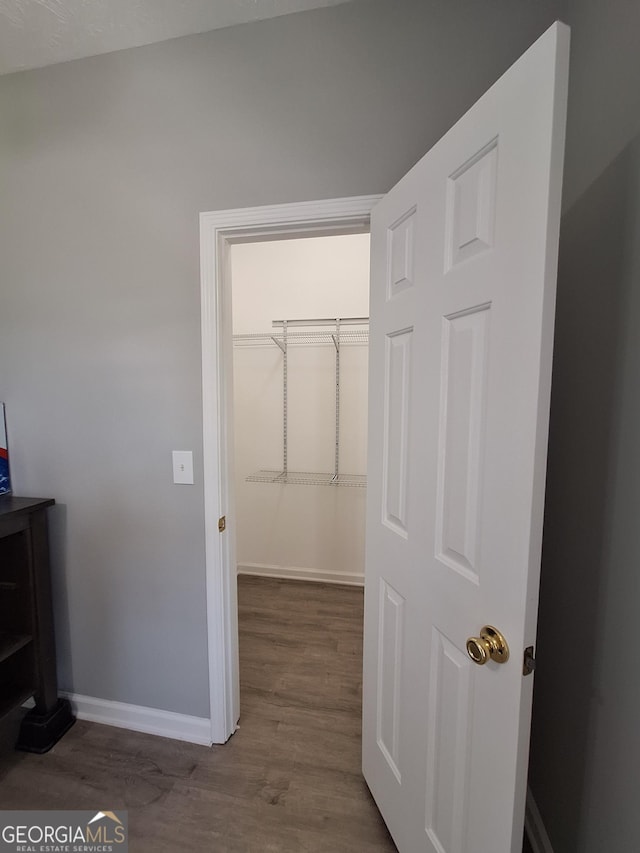 hall featuring wood finished floors and baseboards
