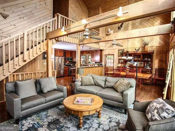 296 Fairview Ct, Jasper, GA 30143 - living area featuring wood walls, a ceiling fan, wood finished floors, and high vaulted ceiling