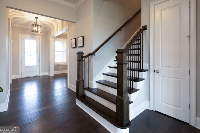 foyer entrance with an inviting chandelier, ornamental molding, stairs, baseboards, and dark wood-style floors