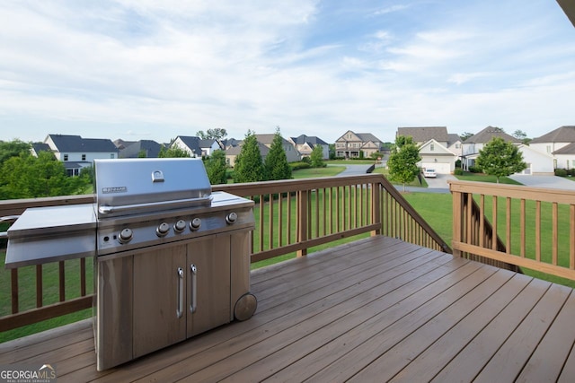 deck featuring a residential view, a lawn, and a grill
