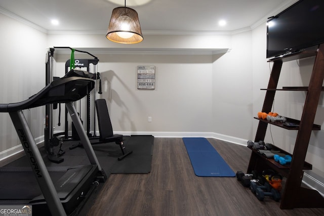 workout area with crown molding, baseboards, and wood finished floors