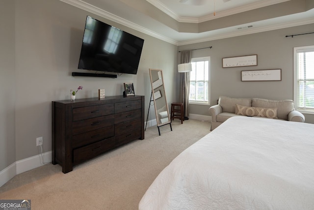 bedroom with crown molding, visible vents, light carpet, baseboards, and a tray ceiling