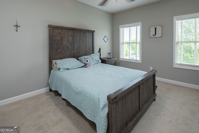 bedroom with baseboards, multiple windows, and light carpet
